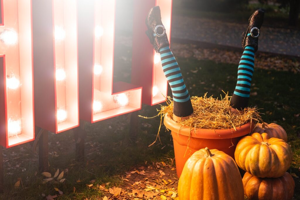 A person's legs sticking out of a pot with pumpkins